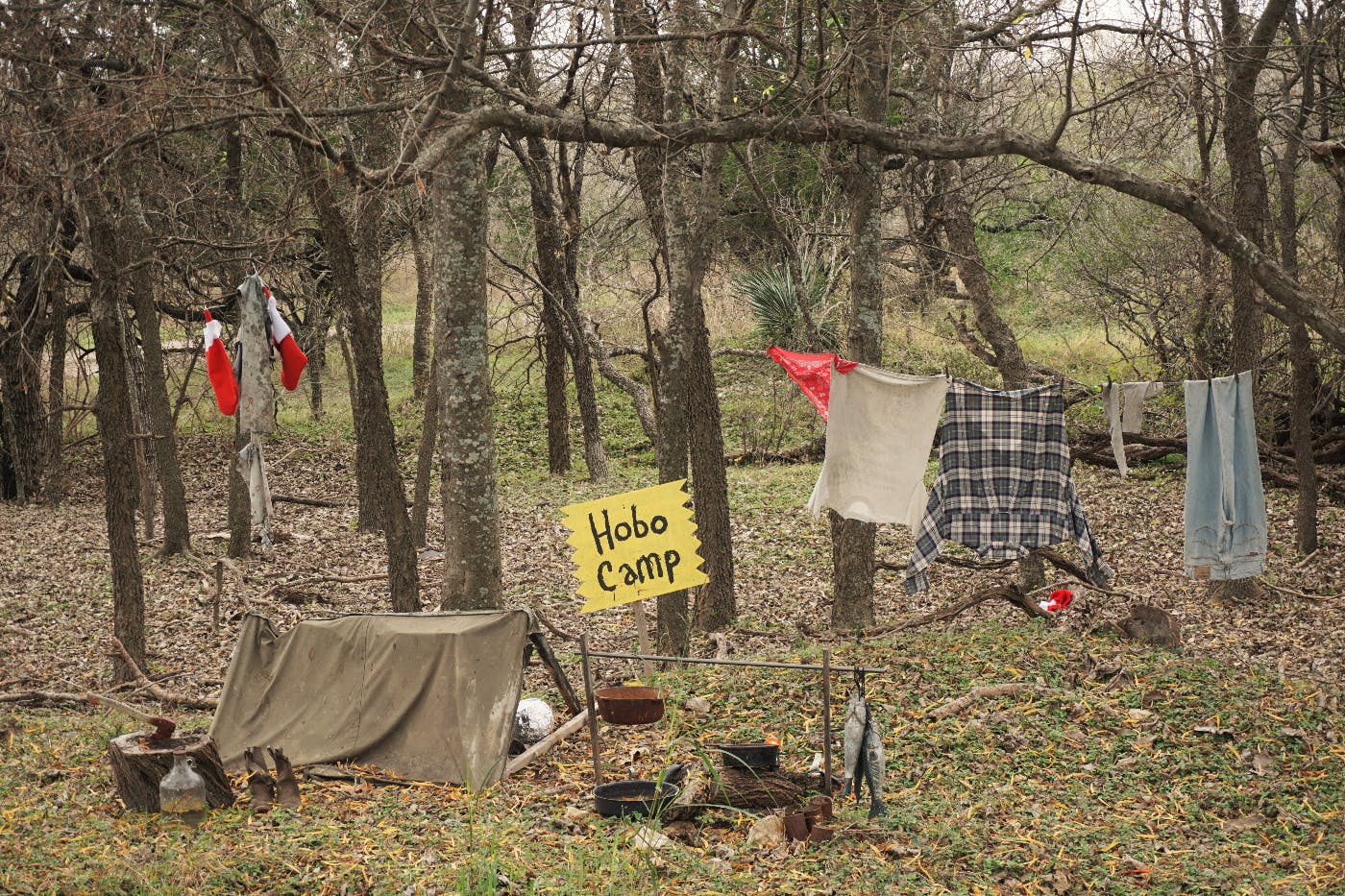 a camp ground with a yellwo sign rescding Hobo Camp