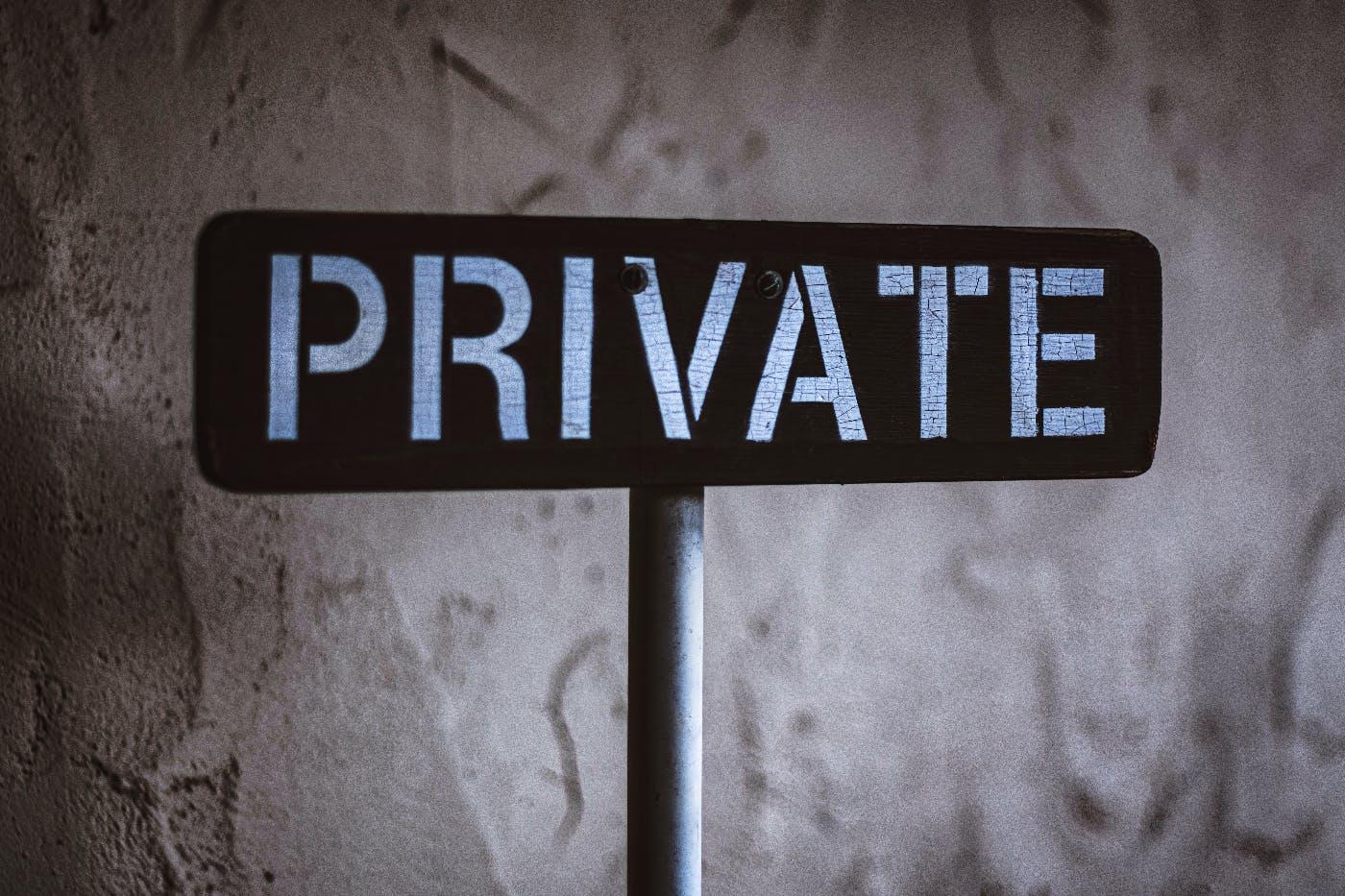 A private sign against a grey wall