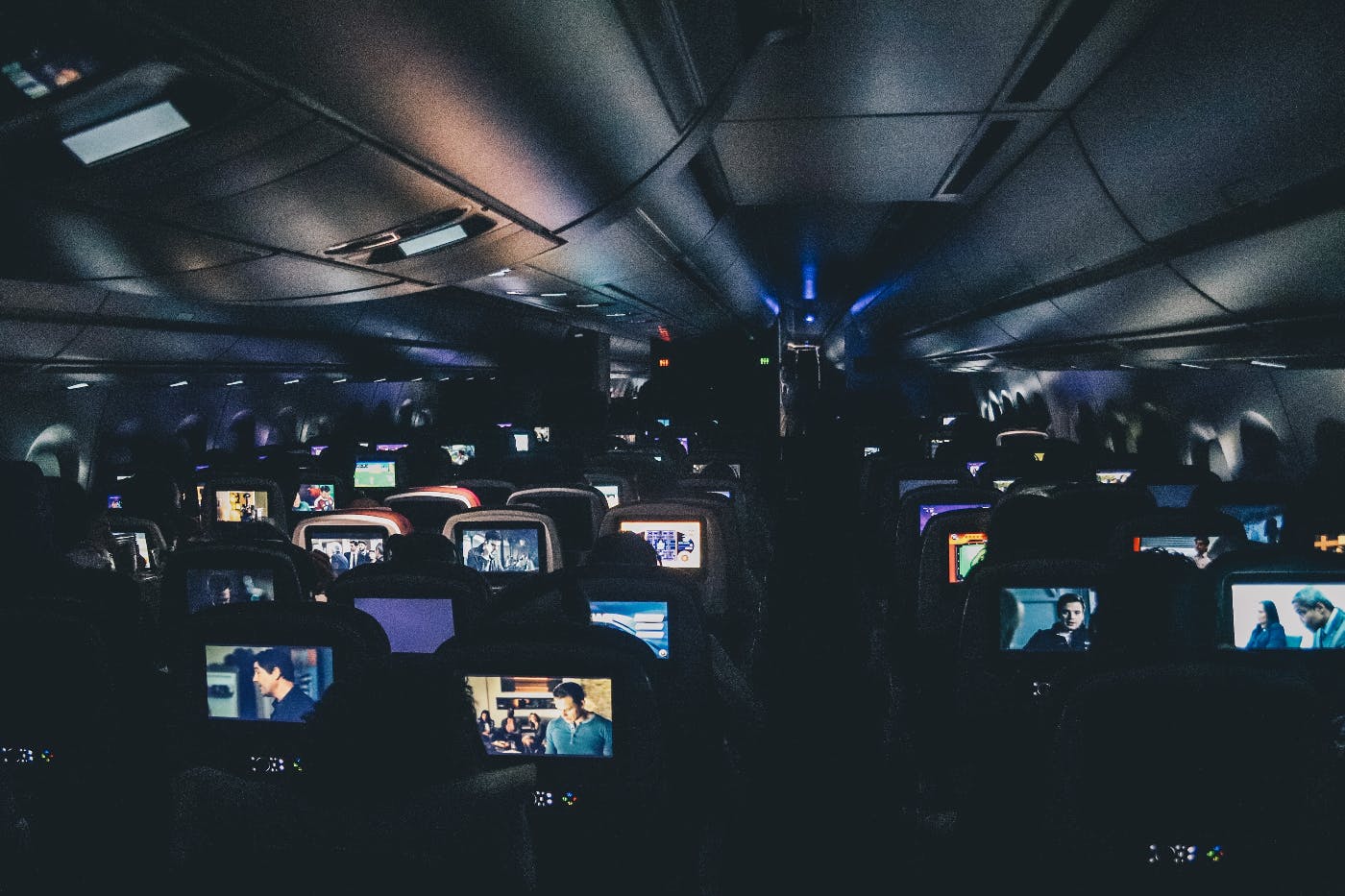 interior of a dark aiprlane with hundreds of TVs on