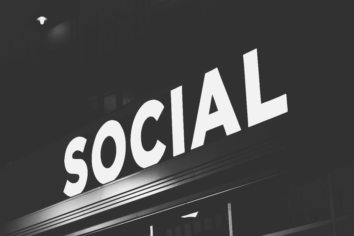 aA black and white image of the word SOCIAL atop a building.