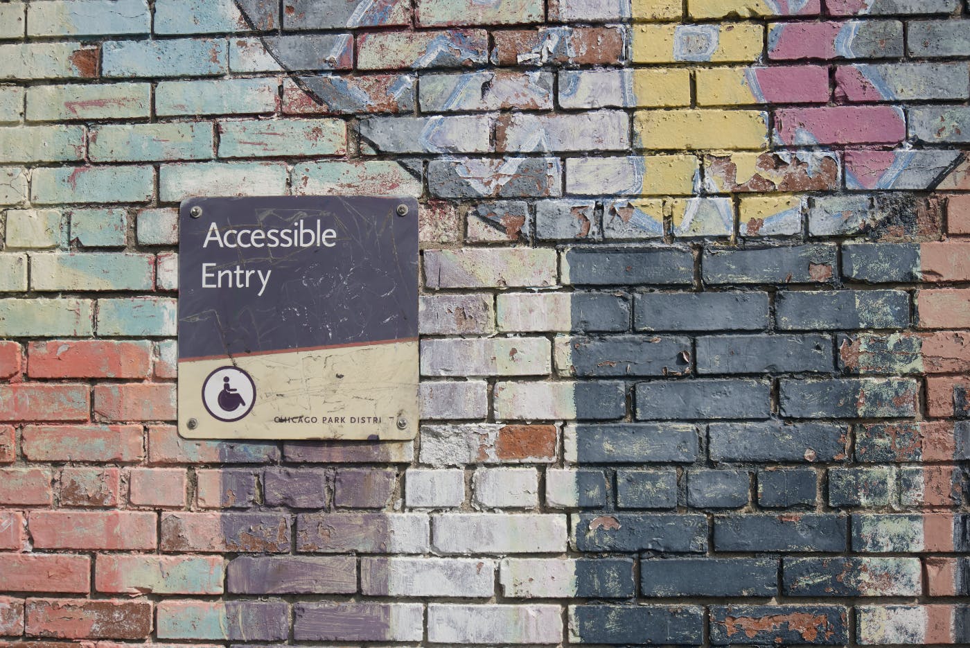 a multi colored brick wall with a wheelchair accessible sign