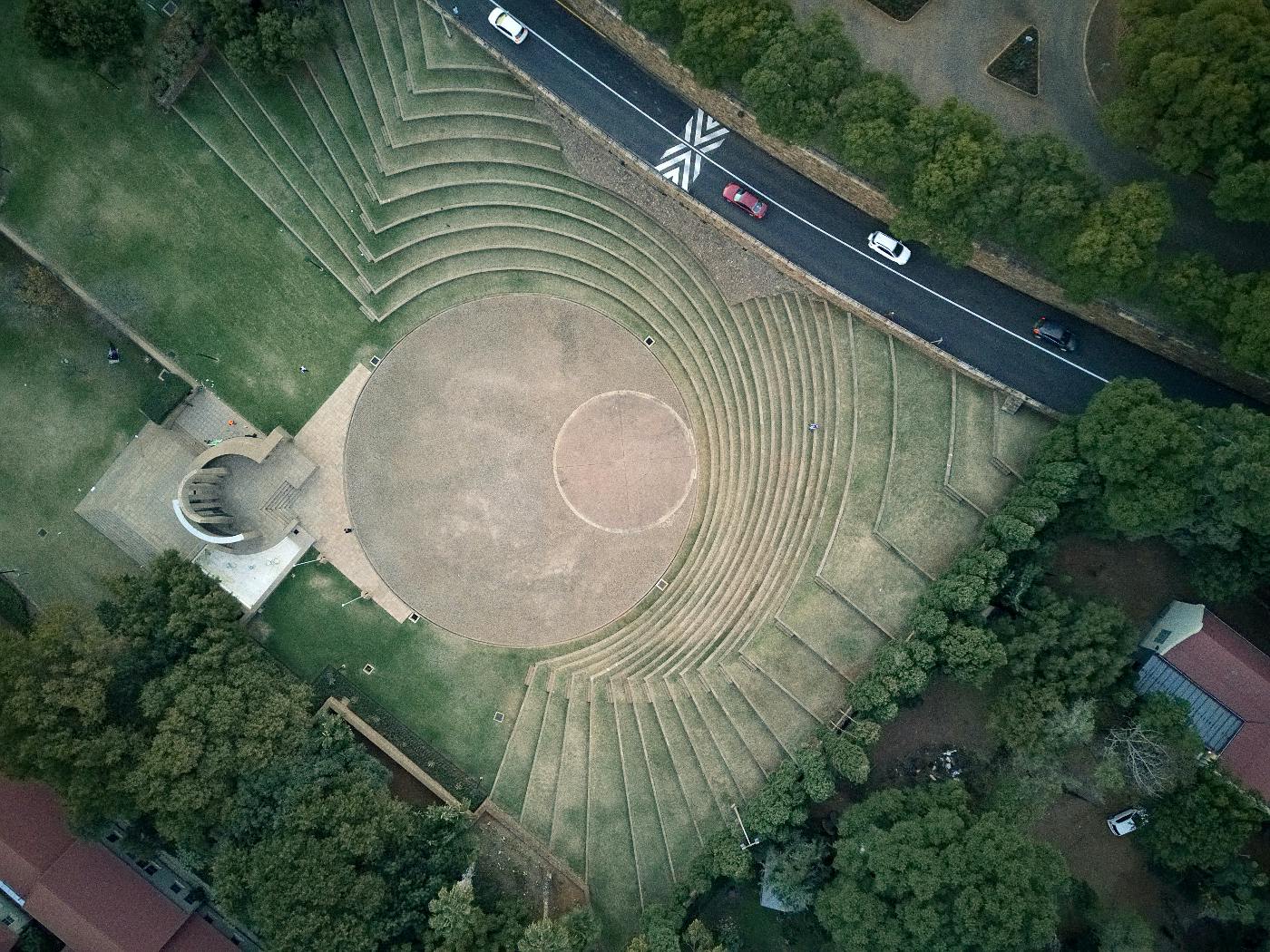 an ancient Roman amphithearter beside a modern highway