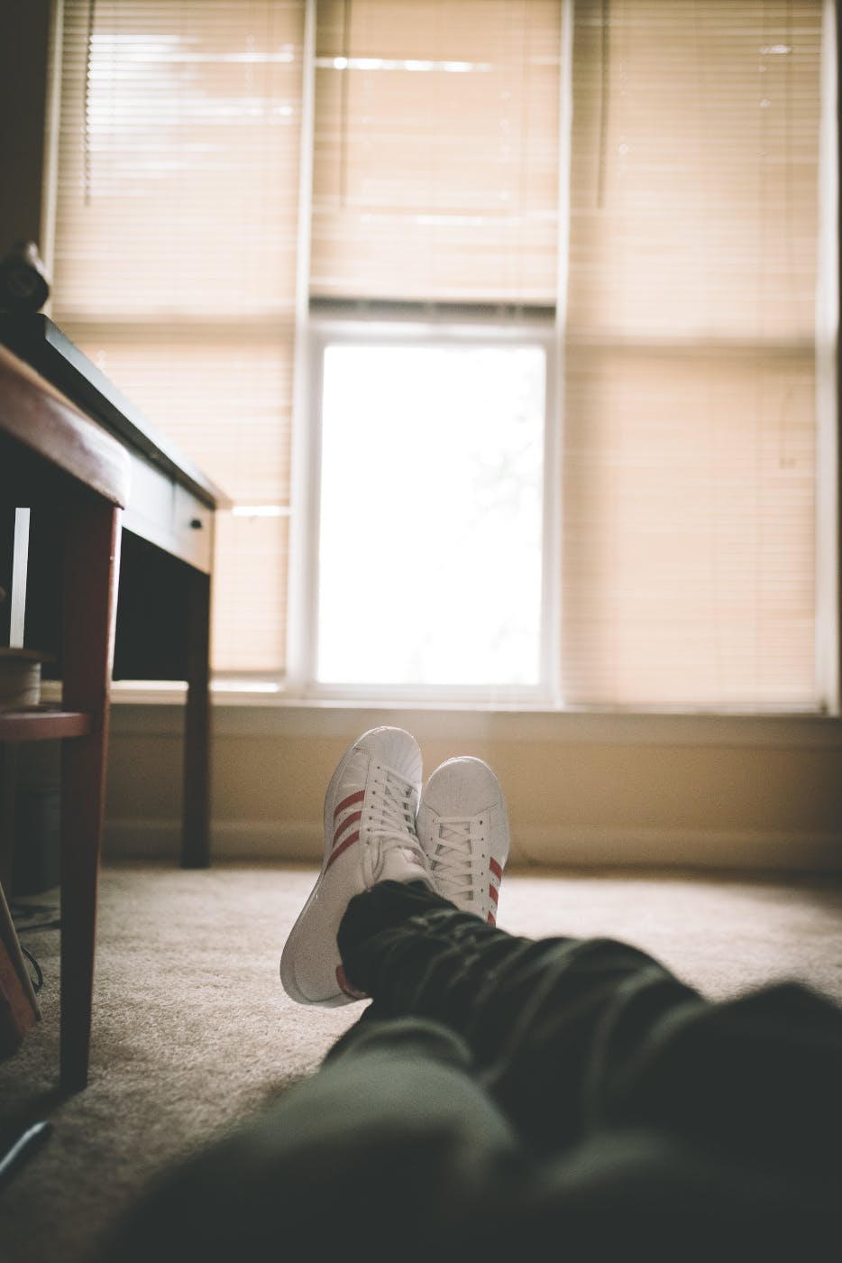 A person laying on the floor and we see only his legs and feet