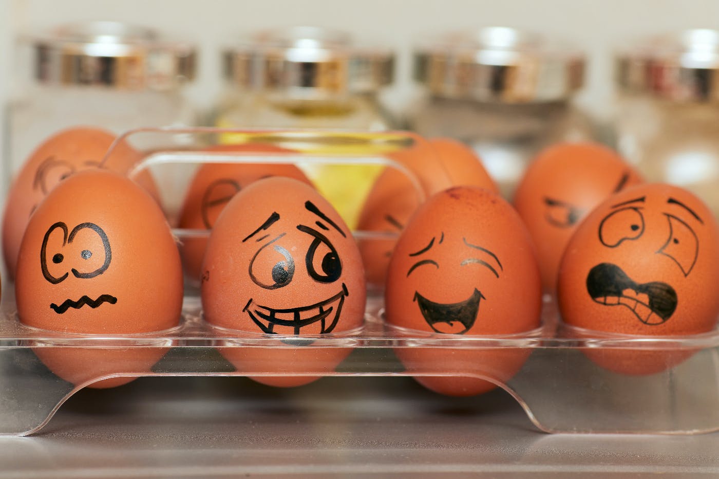 eggs in a tray with faces on them depicting emotional states