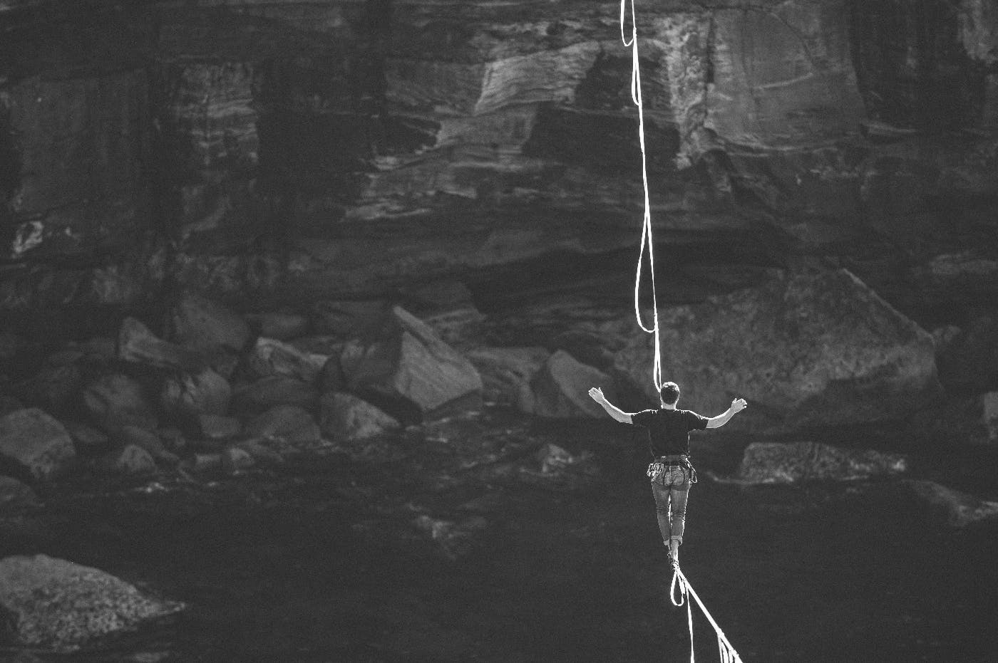 a man walking a wire over a canyon and river