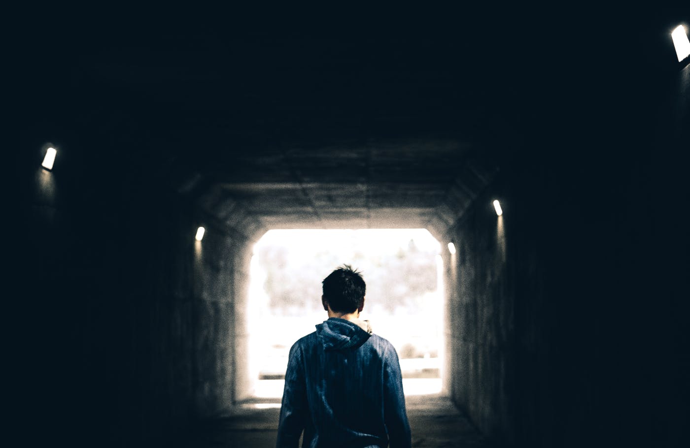 A person walking alone through a dark tunnel