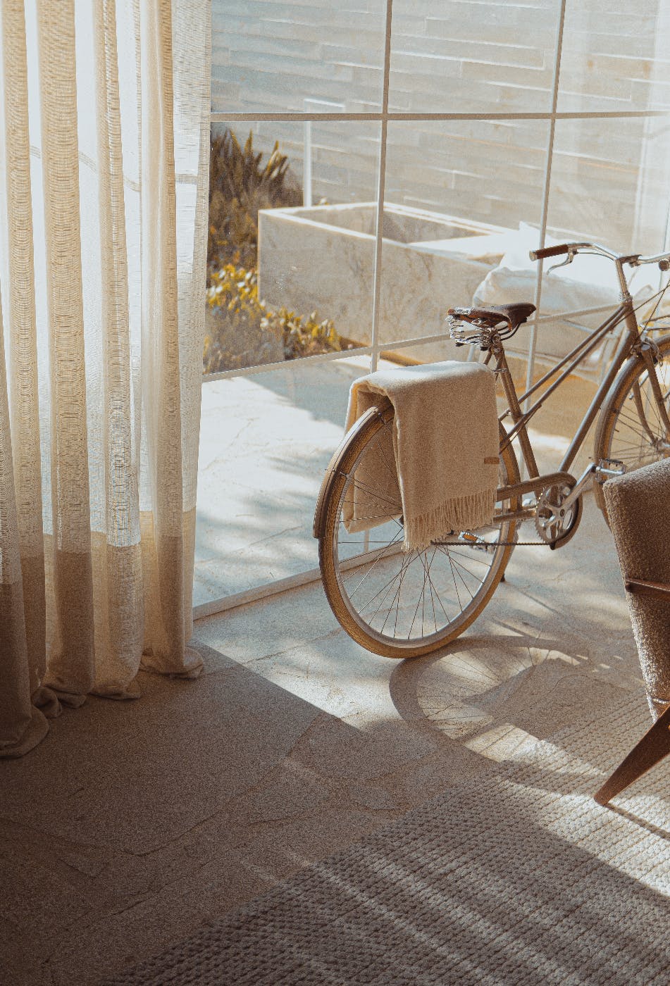 A beige bike in a beige room near a glass door