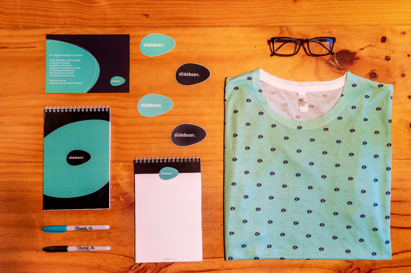 Notebooks, pens, note cards, glasses and a shirt all in branded colors