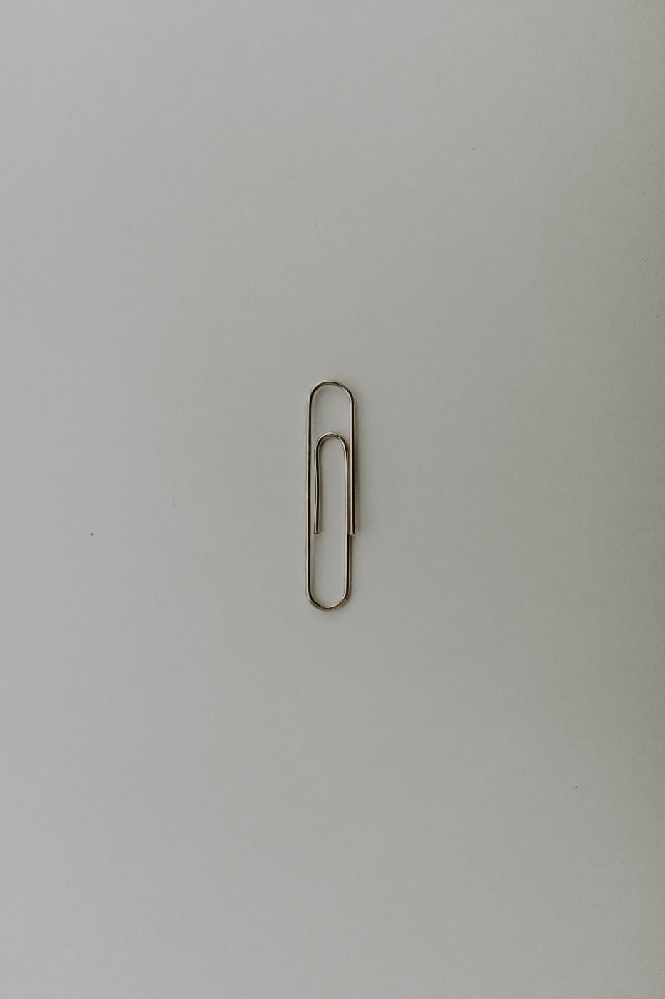 a single paper clip on a gray background