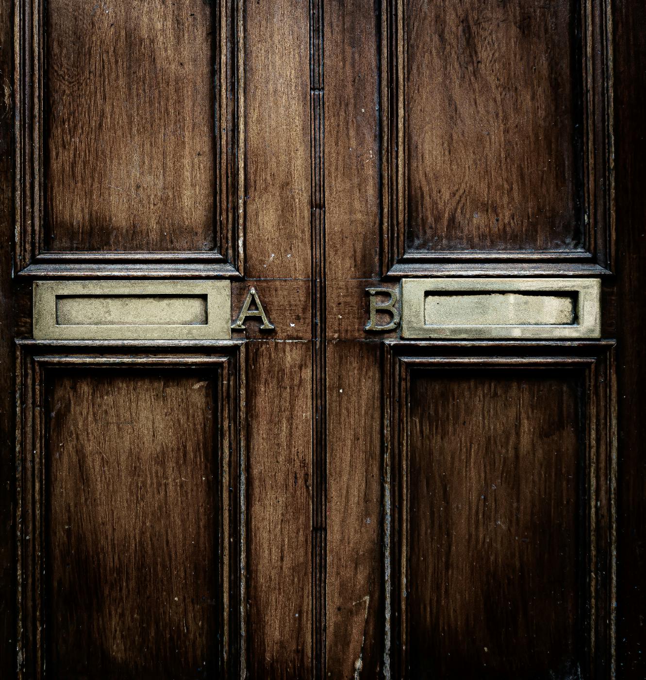 Two mail slots on a door, left A, right B