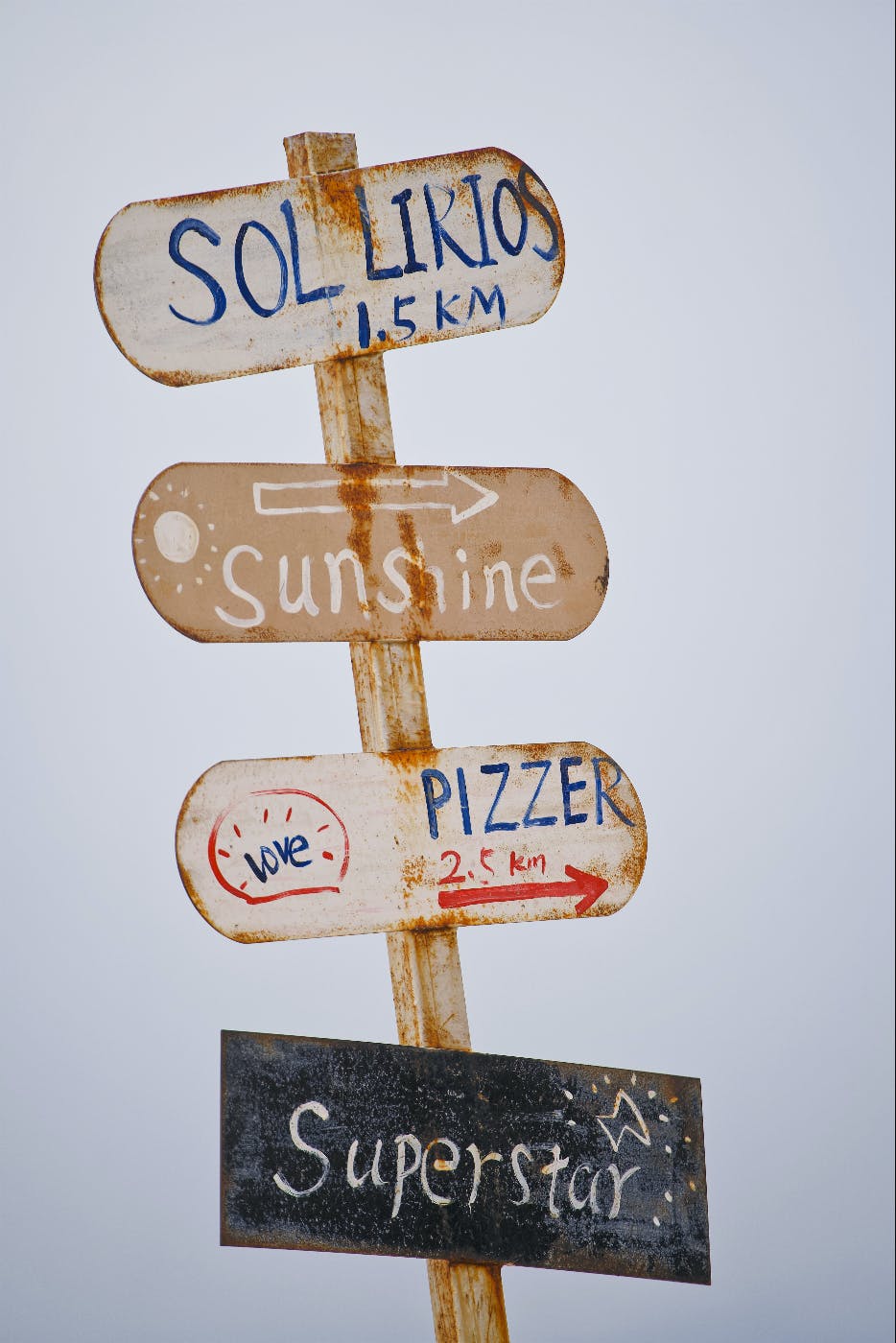 A sign post with: Sol Likios, Sunshine, Pizzer and Superstar signs on it