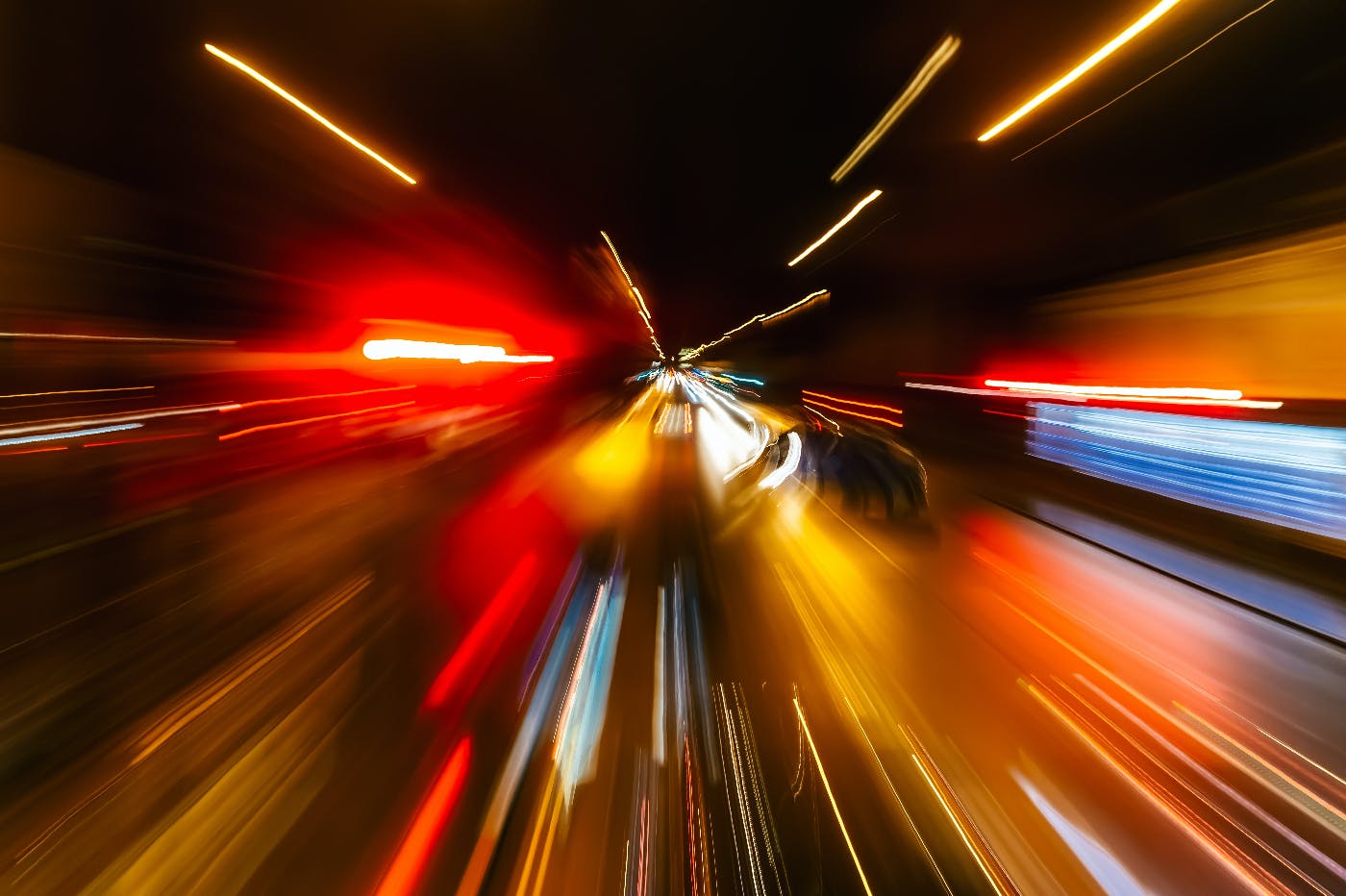 a long exposure of a city street making cars in motion look like streaks of colored lights