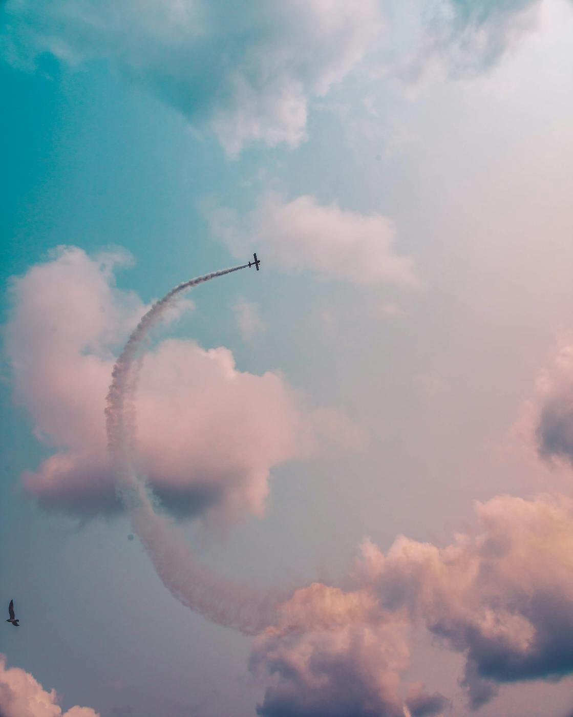 a plane leaving a contrail as it moves among the clouds