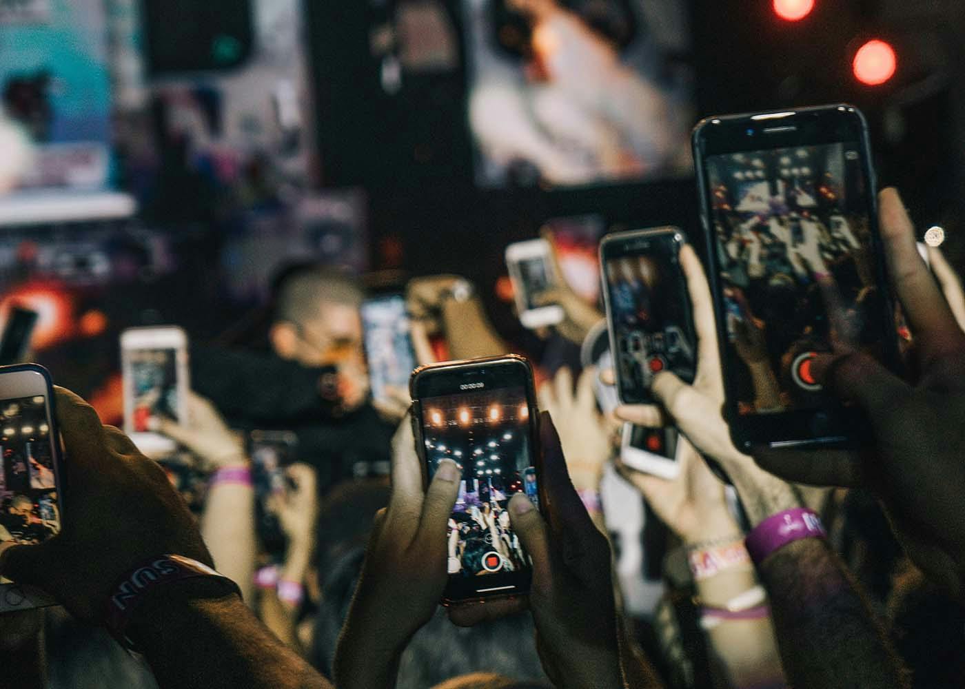 People recording a concert with their phones