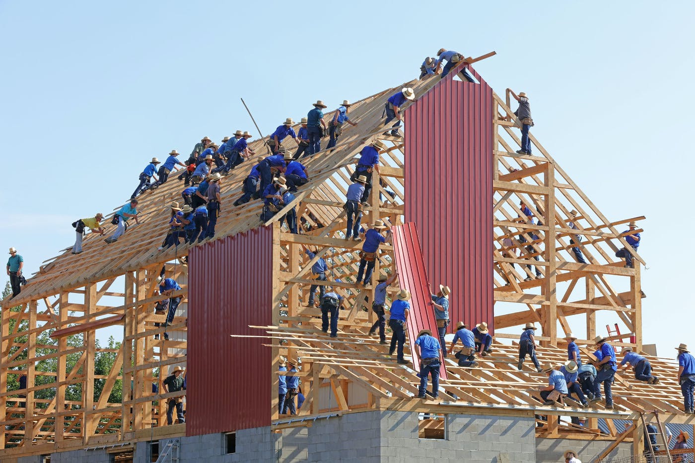 Many Menonite men building a barn