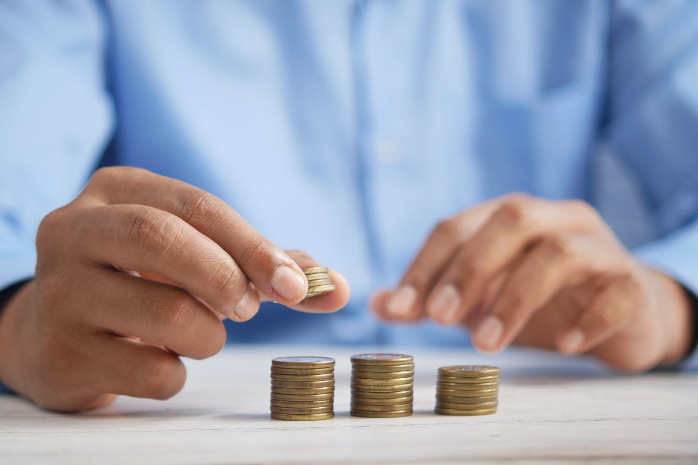 A man in a blue short stacking coins