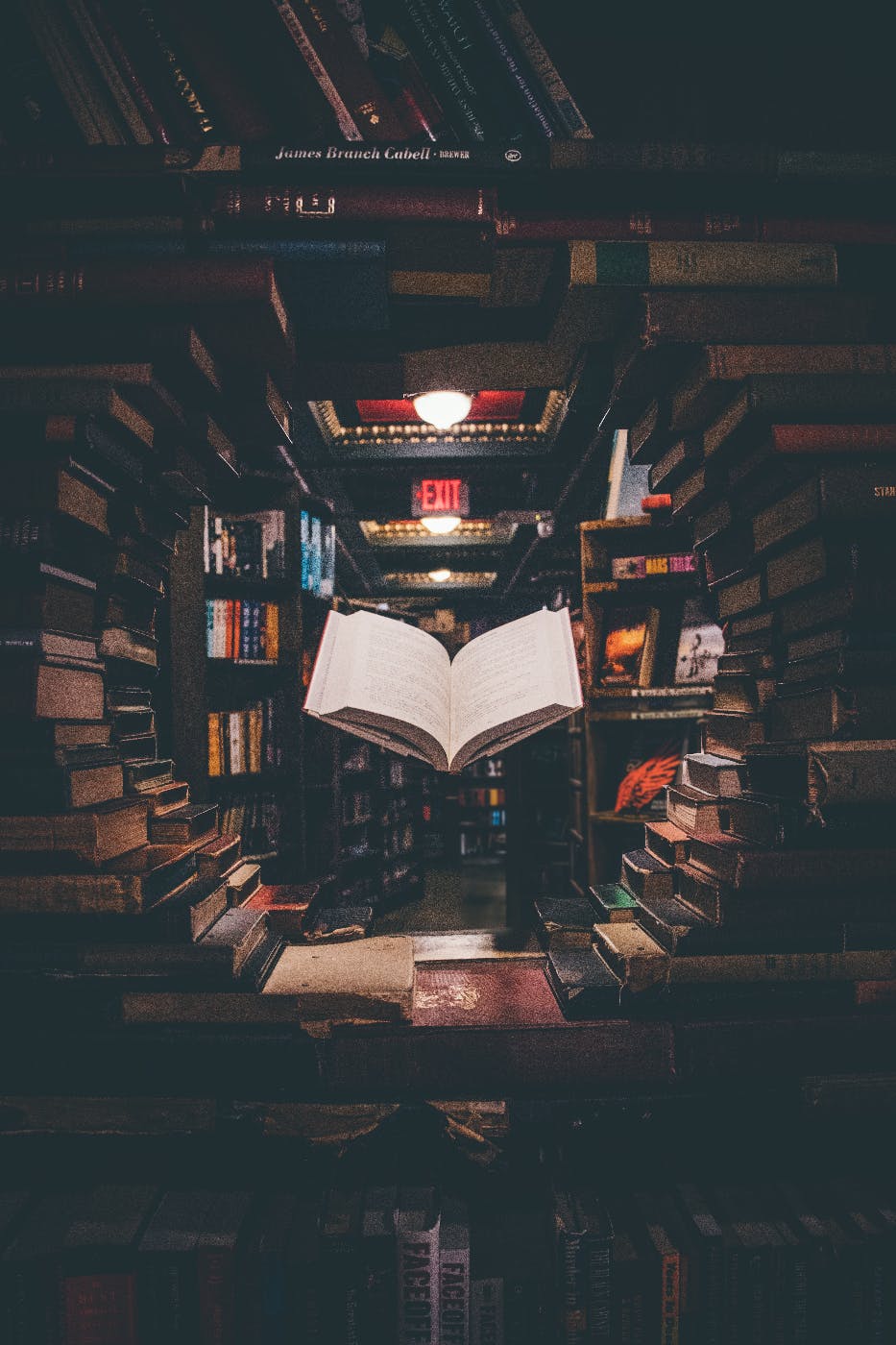 An open book floating among stacked books