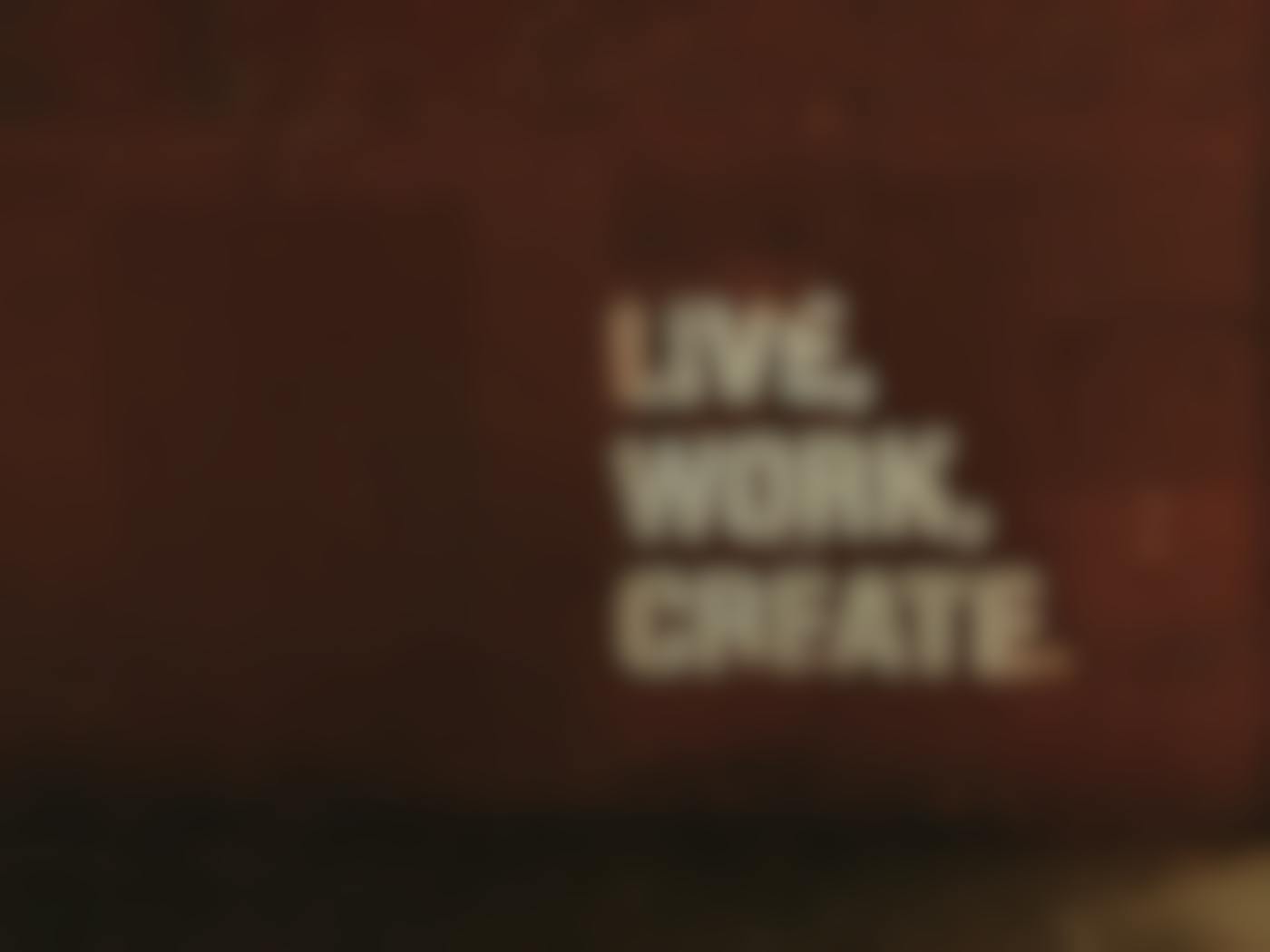 A brick wall with Live, Work, Create apinted on it.