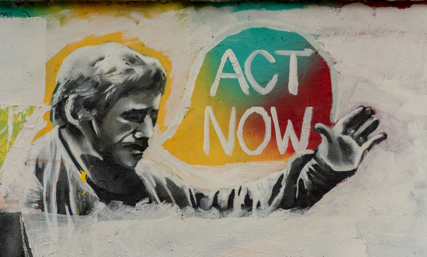 Wall graffiti of a man saying act now