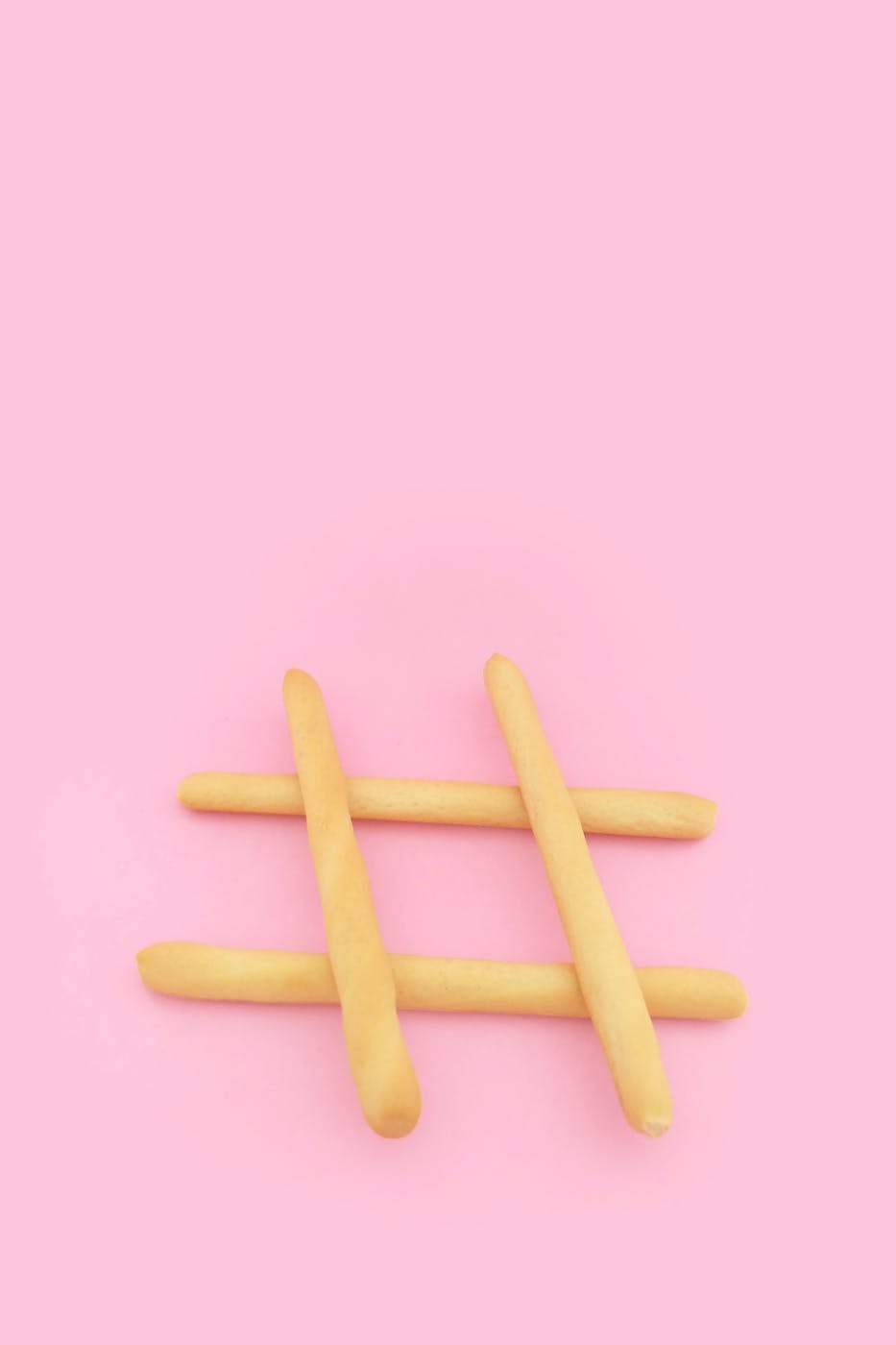 a hashtag made from four baguettes in front of a pink background