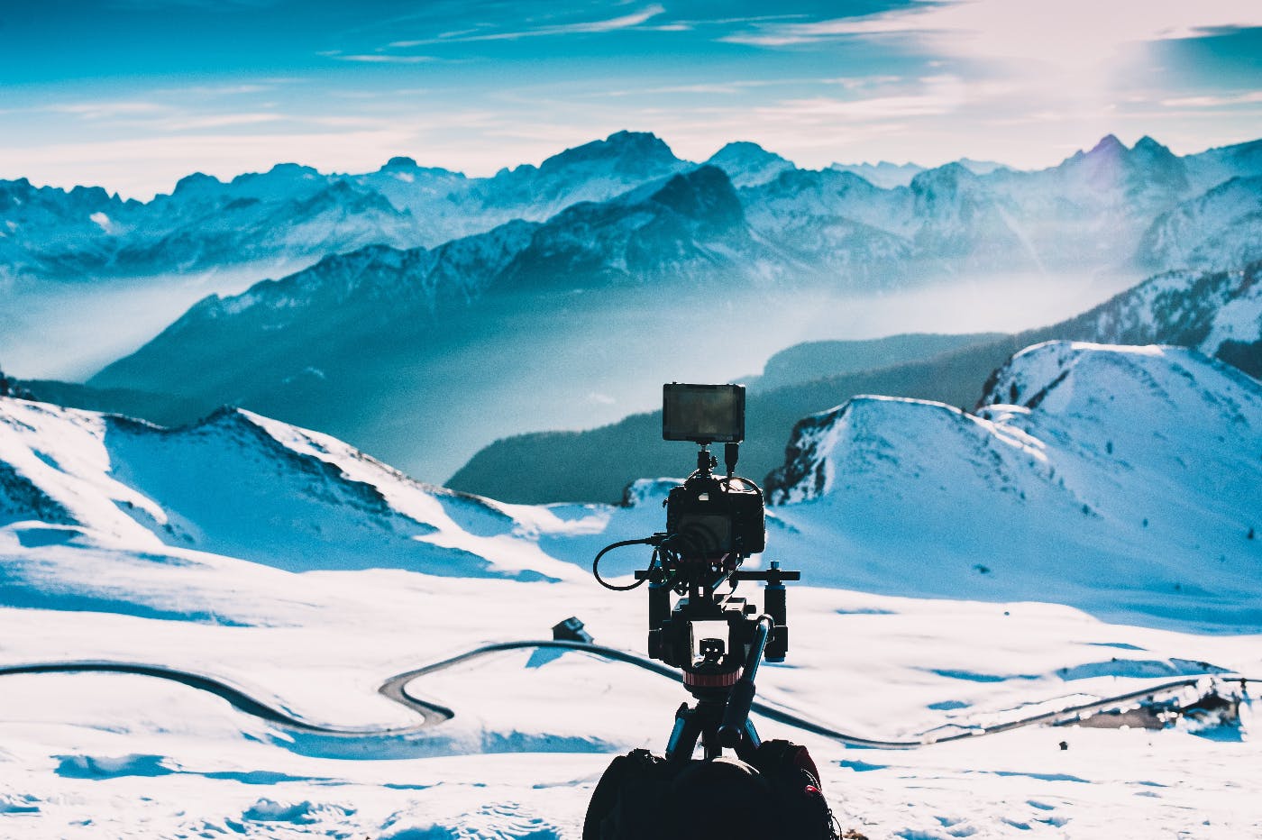 A video camera set up facing a snow covered mountain range