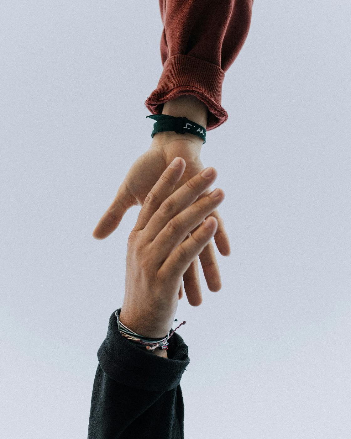 Two hands reaching toward a handshake