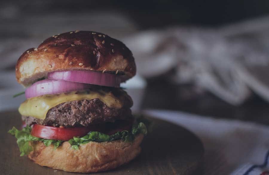 cheeseburger with onions tomato and lettuce