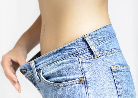 woman pulling jean waistband