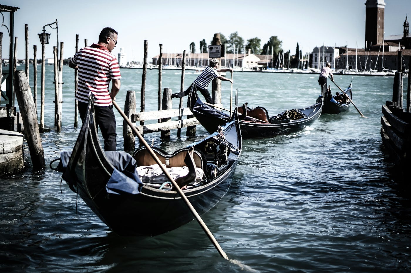 Three Gondoliers moving their gondolas out into the canals