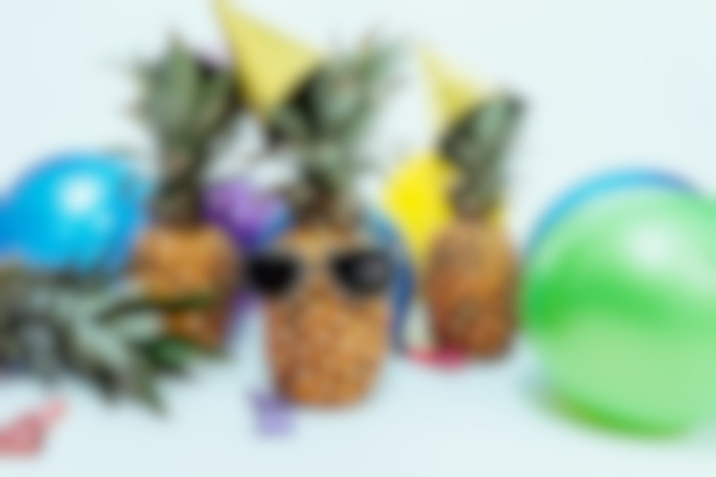 3 pineapples at a party, one wearing sunglasses