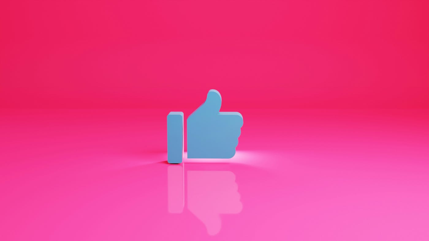 The blue thumbs up icon in front of a pink background