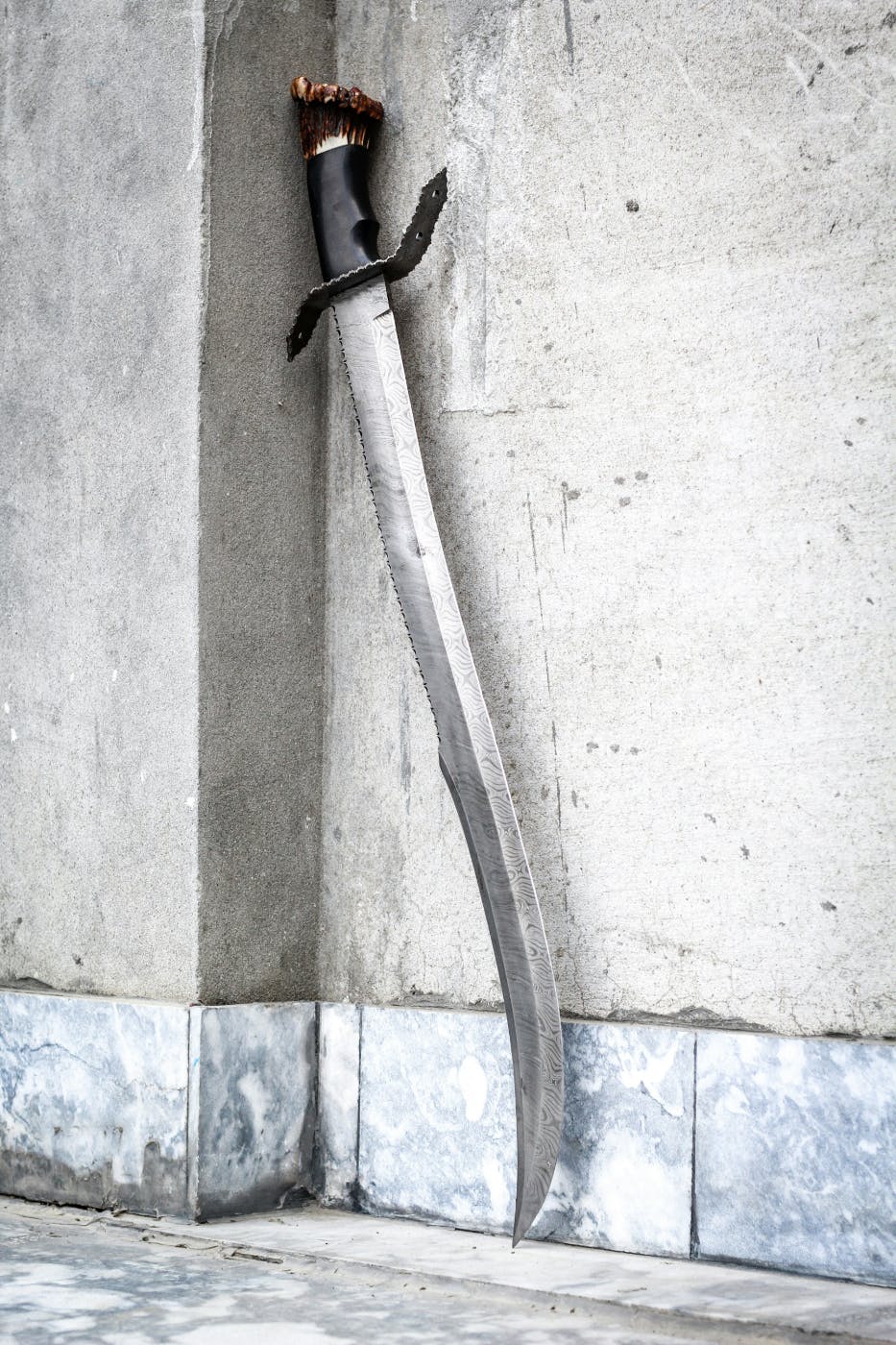 A cavalry sabre leaning against a marble wall