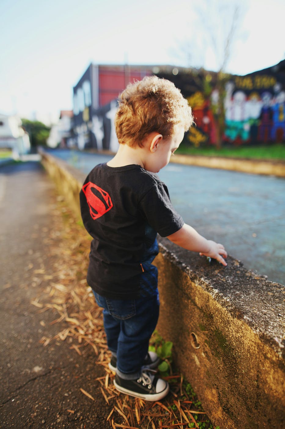 A small boy wearing a black Superman T-shirt