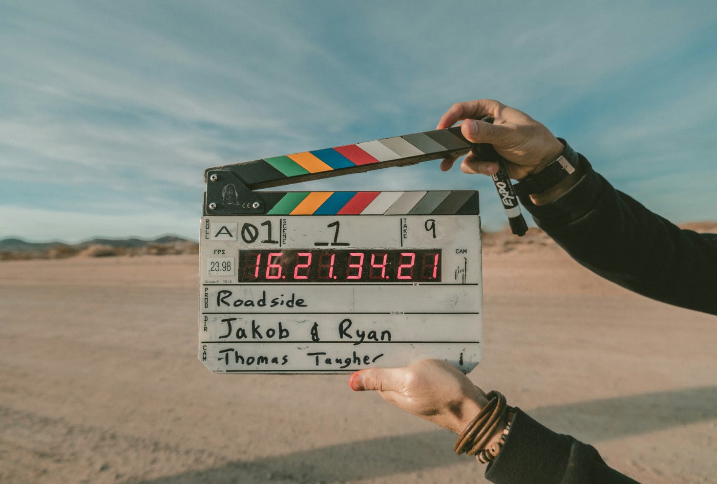 Two arms holding a film clapper