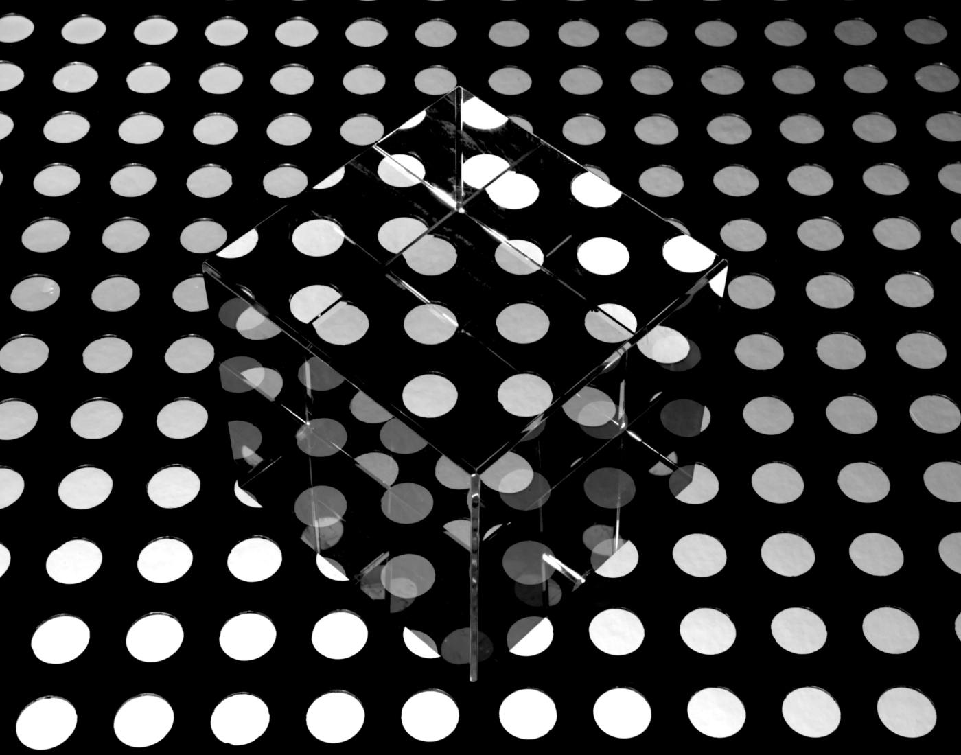 A clear cube on a polka dot background