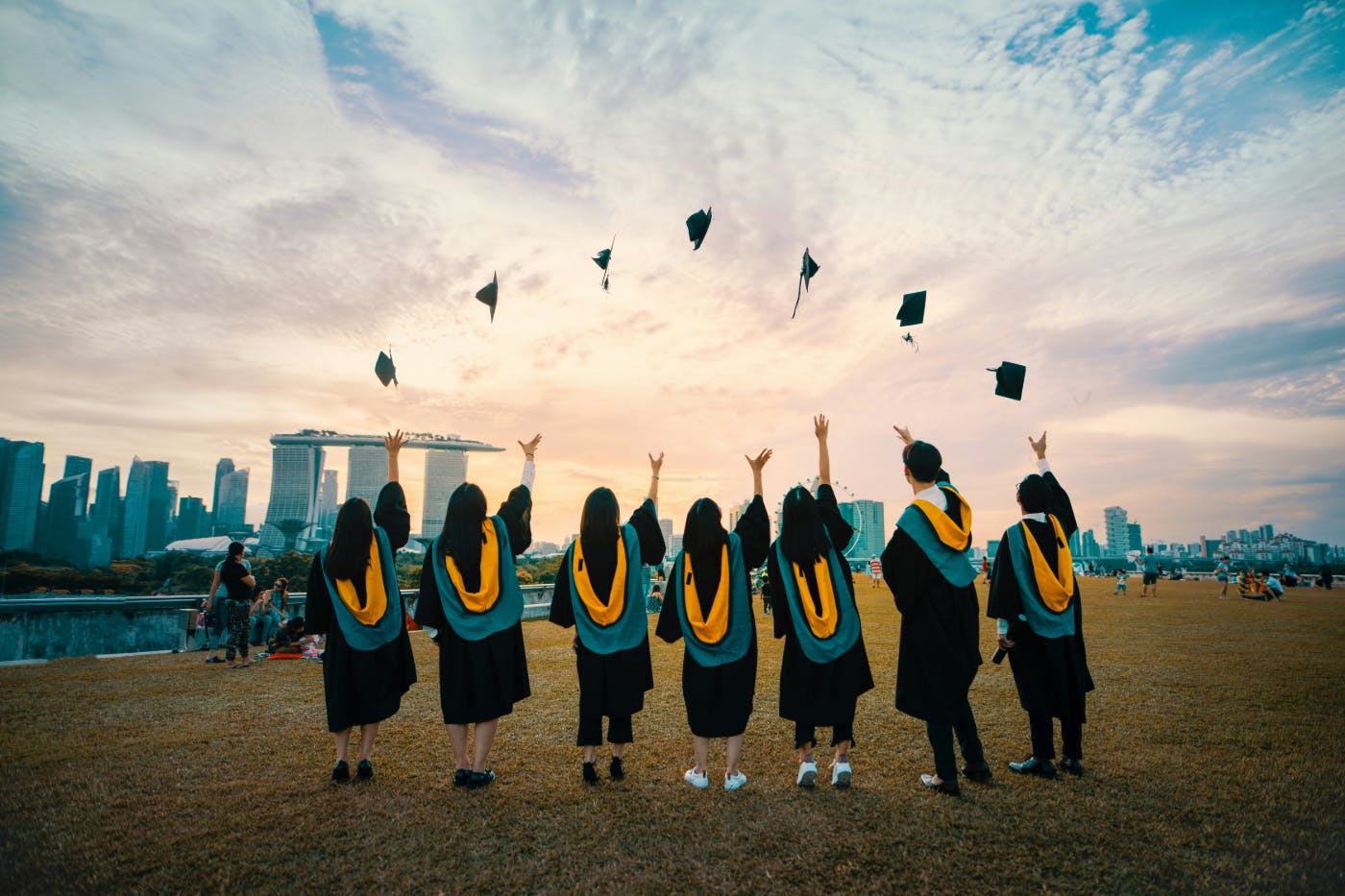 A line of students throwing their graduation caps in the air