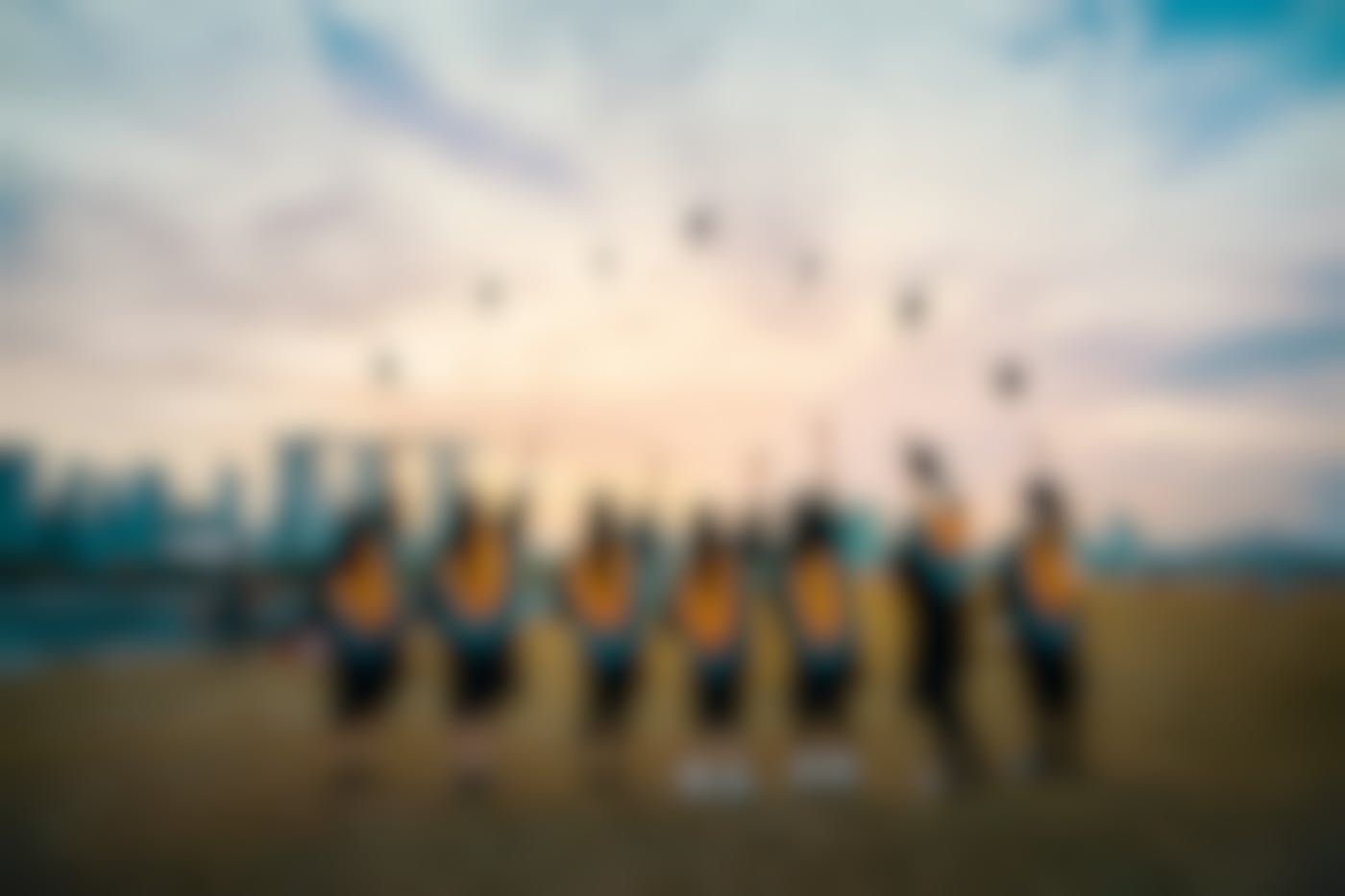 A line of students throwing their graduation caps in the air