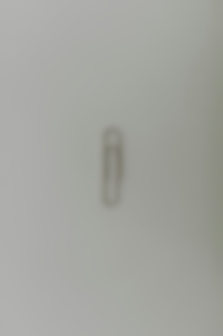 A single paper clip on  a gray background