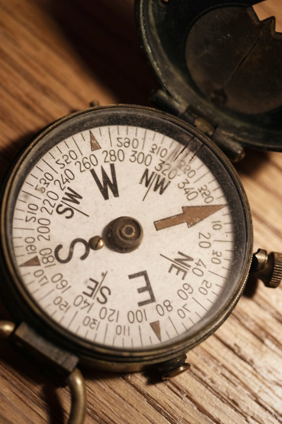 an old brass compass on a wood table