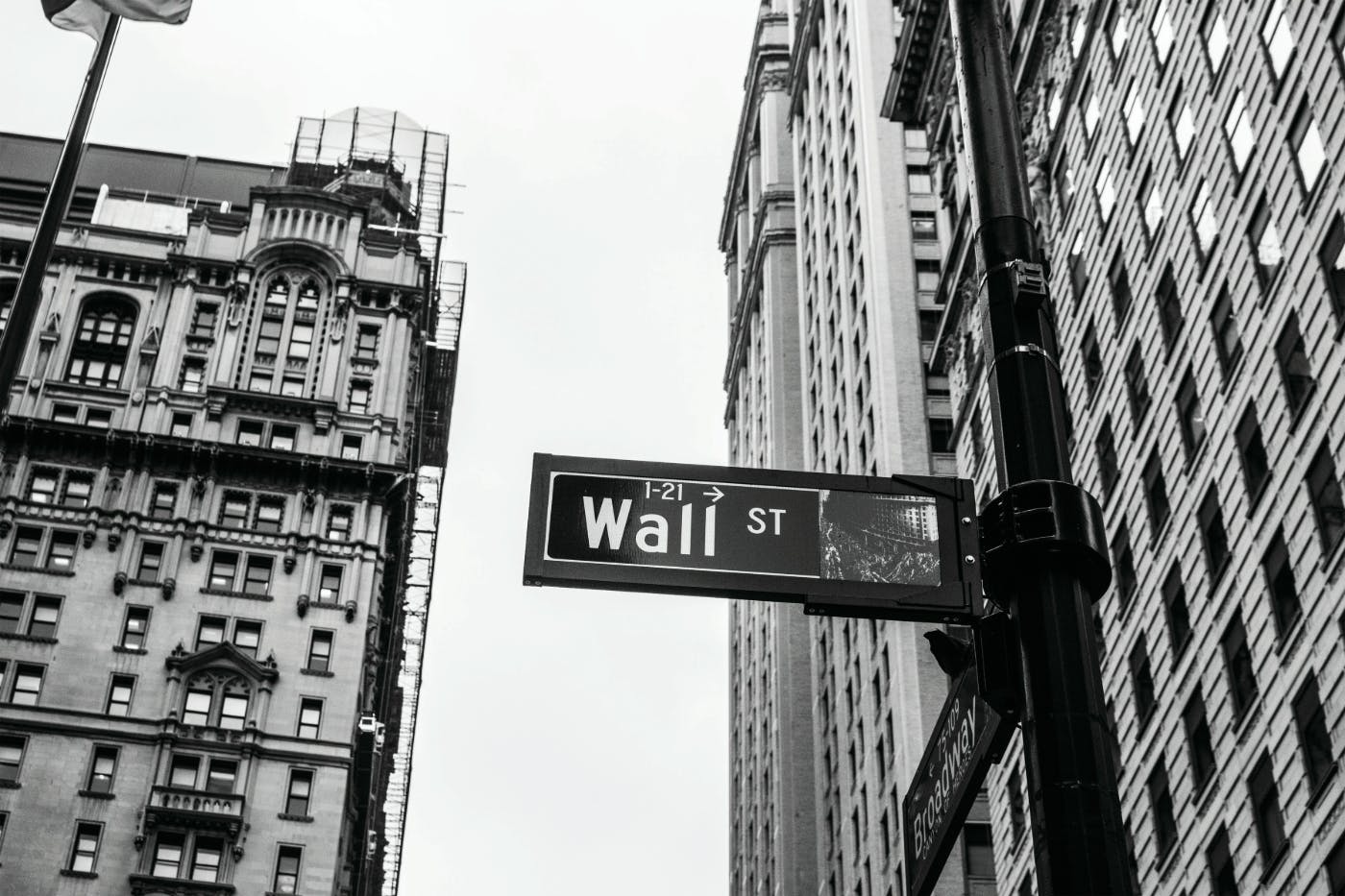 A gray scale photo of the Wall Street sign and buildings