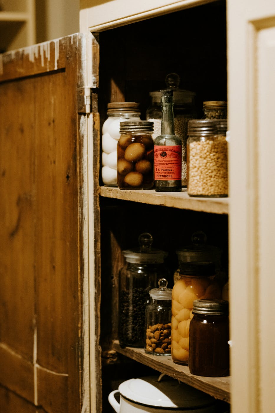 Various jarred and bottled items in a rustic pantry