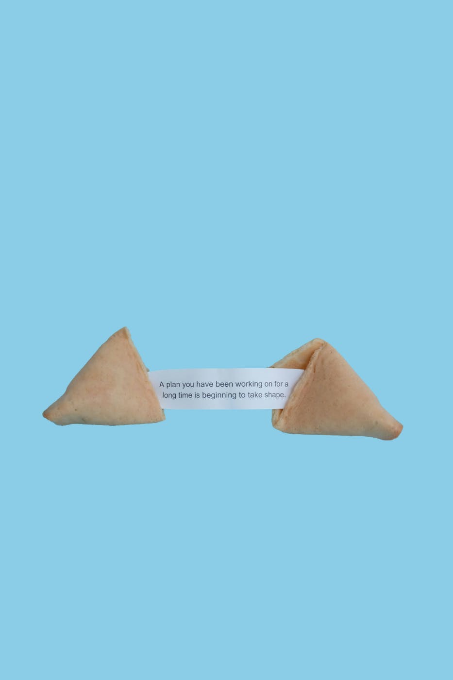 A split fortune cookie with the fortune reading: A plan you've been working on for a long time is beginning to take shape