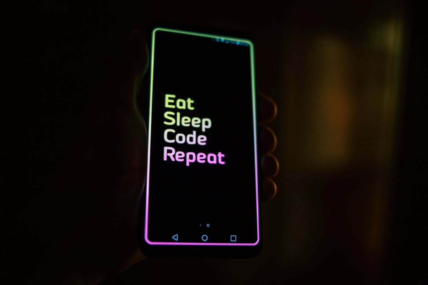 A lit smartphone screen with the words: Eat. Sleep. Code. Repeat.