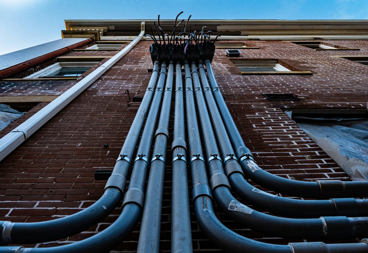 conduits on the side of a brick building