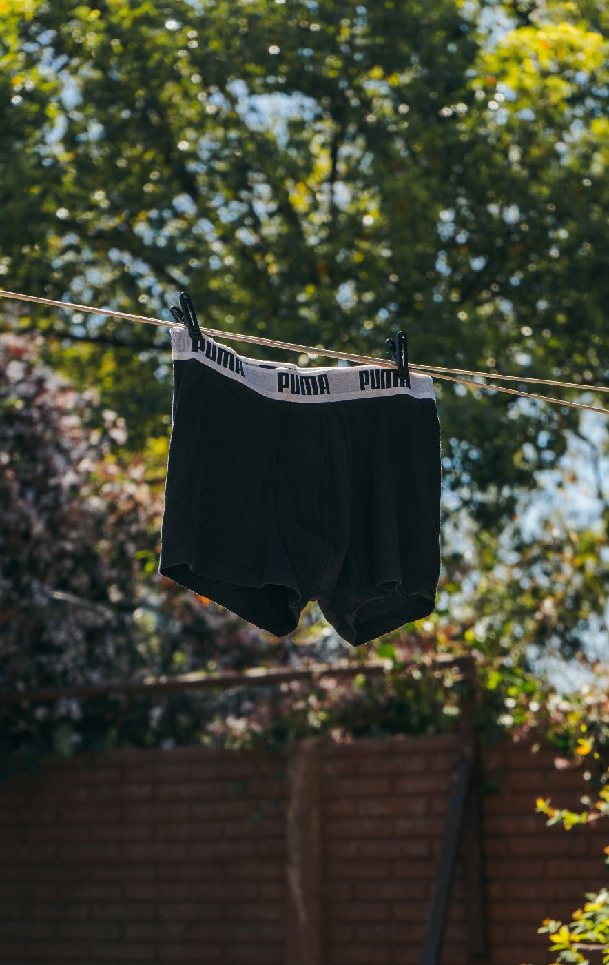 a pair of men's Puma black boxer-briefs hanging on a clothes line