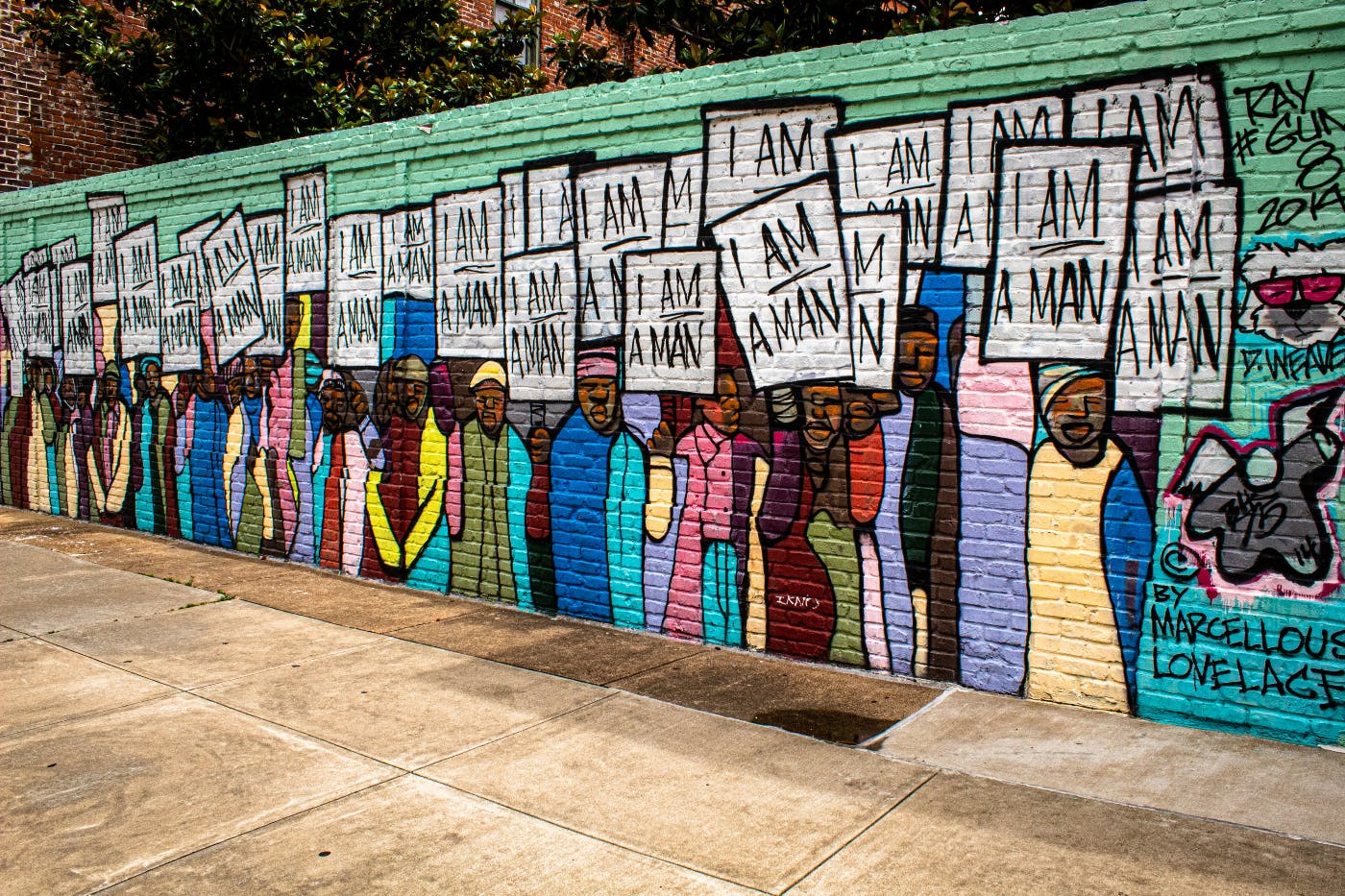 A wall mural with hundreds of men holding signs reading I Am A Man