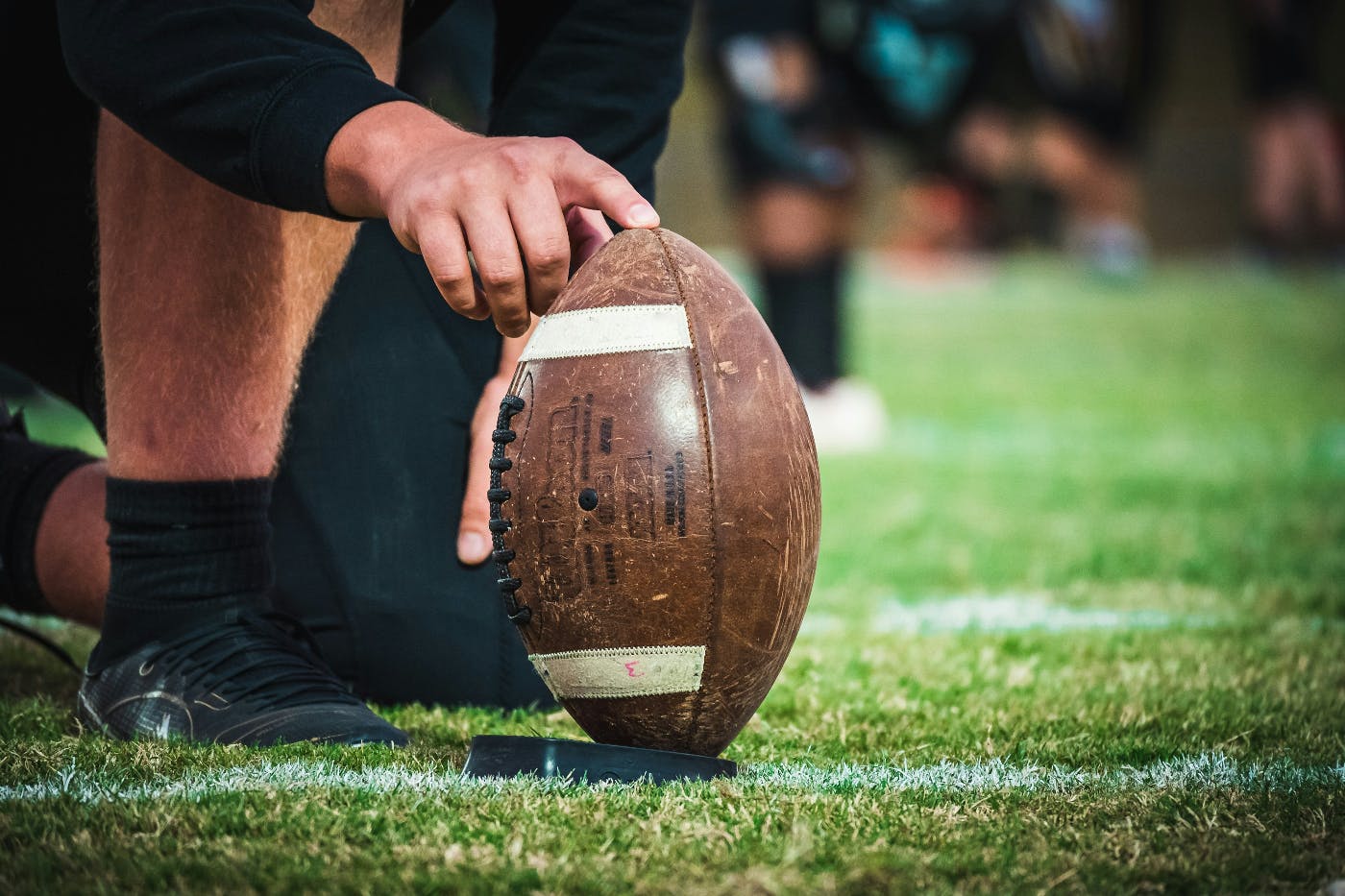 A man holding an American football in position for a kick-off