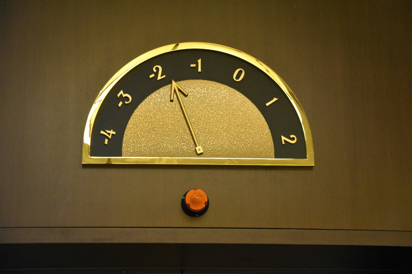 A black and gold floor indicator above elevator doors
