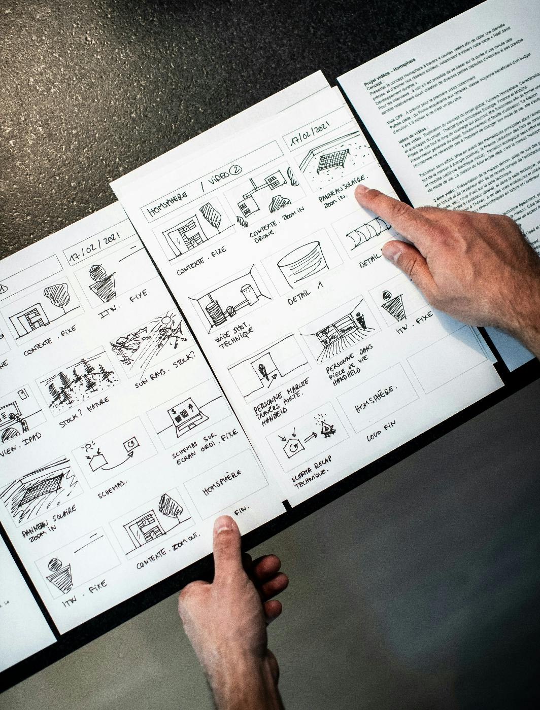 A hand drawn storyboard in a black notebook