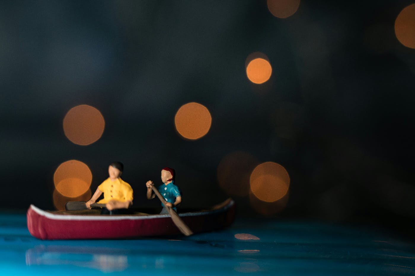A small wood carving of two people in a red canoe